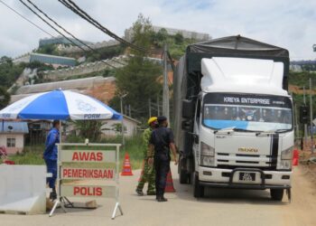 ANGGOTA Keselamatan mengawal pintu masuk Kampung Lojing dan Kampung Sendrop di Tanah Tinggi Lojing, Gua Musang yang dikenakan PKPD bermula semalam. - UTUSAN/AIMUNI TUAN LAH