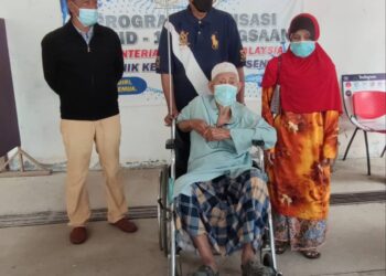 ZAKARIA Jab (berkerusi roda) ditemani Mahfuz Omar (tengah) dan Kalsom Hussin ketika hadir menerima suntikan vaksin Covid-19 di Klinik Kesihatan Pokok Sena, Alor Setar hari ini. - UTUSAN/NUR ANATI JUHARI