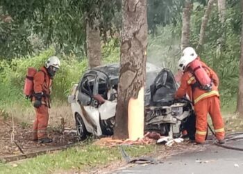 ANGGOTA bomba memadamkan kebakaran sebuah kereta terbakar selepas melanggar pokok yang mengakibatkan pemandunya maut dalam kejadian di Jalan Sungai Jai, Lenggeng, Seremban hari ini.-Gambar ihsan bomba