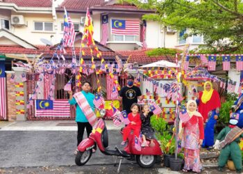 MOHD. Firdaus Daud bersama kelaurga bergambar di hadapan kediamannya selepas terpilih menjadi juara Rumah Cinta Malaysia bersempena Kempen Kibar Jalur Gemilang KRT LEP 5, di Taman Lestari Putra, Seri Kembangan Selangor.