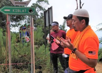 AMRAN Awaludin (kanan) membaca doa selepas program memasang arah kiblat di puncak Gunung Angsi, Kuala Pilah hari ini.