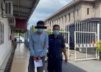 SEORANG juruteknik IT (kiri) yang dituduh atas kesalahan mengugut seorang gadis berusia 14 tahun untuk menyebarkan gambar pornografi tiba di perkarangan Kompleks Mahkamah Kangar, Perlis hari ini. - UTUSAN MALAYSIA/NAZLINA NADZARI