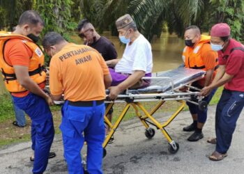 ANGGOTA APM membantu memindahkan seorang mangsa banjir yang uzur setelah rumahnya dinaiki air dalam kejadian banjir di Kampung Gua Tinggi, Kuala Ketil, Baling hari ini.