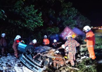 ANGGOTA bomba mengeluarkan mangsa yang tersepit dalam kereta yang terlibat kemalangan di Kilometer 392.1, Lebuh Raya Utara-Selatan arah selatan dekat Tanjung Malim hari ini.  - UTUSAN/IHSAN JBPM PERAK