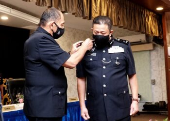 MIOR Faridalathrash Wahid (kiri) memakaikan pangkat kepada Azizi Mat Aris pada Majlis Serah Terima Tugas Jawatan Timbalan Ketua Polis Perak di Mes Pegawai Kanan PDRM Perak di Ipoh. - UTUSAN/ZULFACHRI ZULFACHRI