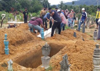 AHLI keluarga terdekat dibantu kakitangan Masjid Pekan Gurun menguruskan  pengkebumian Sarah Jon dan anak lelakinya di Tanah Perkuburan Islam Sungai Badak, Gurun hari ini.  - UTUSAN/OTHMAN YAHAYA