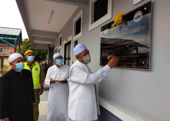 AHMAD Yakob (kanan) menurunkan tandatangan sebagai simbolik perasmian Wisma Ilmu di Masjid Mukim Ismaili, Kampung Morak, Tumpat, Kelantan. - UTUSAN/YATIMIN ABDULLAH