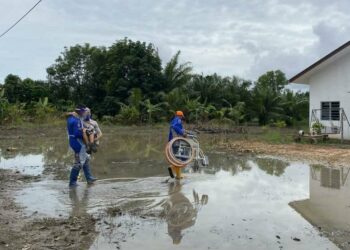 ANGGOTA APM Kedah membantu mangsa banjir pulang ke rumah selepas banjir mulai surut di Kampung Banggol Besi, Pendang hari ini.