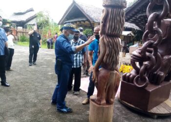 RAIS Yatim memerhatikan salah satu arca ukiran kayu di Perkampungan Orang Asli Suku Mah Meri di Pulau Carey, Selangor hari ini. - UTUSAN/MOHAMAD NAUFAL MOHAMAD IDRIS