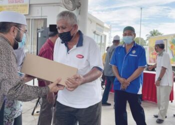 NIK Muhammad Zawawi Salleh menyampaikan bantuan one-off dan Prihatin MAFI kepada salah seorang pemandu teksi di Pasir Puteh baru-baru ini. - UTUSAN/TOREK SULONG