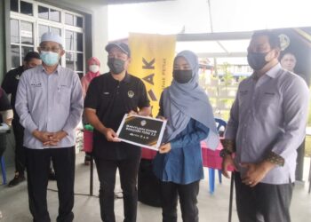 AHMAD Saidi Mohamad Daud (kanan) bersama menerima sumbangan Bantuan Mahasiswa 2.0 di Kuala Kurau dekat Parit Buntar hari ini. - UTUSAN/WAT KAMAL ABAS