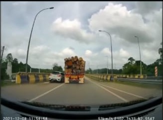 TANGKAP layar video Perodua Myvi hampir bergesel dengan lori yang penuh dengan muatan kayu balak.