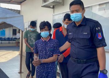 SEORANG penganggur (tengah) direman dua hari kerana memiliki tiga kad pengenalan milik orang lain dan tidak mempunyai kad pengenalan sendiri ketika keluar dari pekarangan Kompleks Mahkamah Kangar, Perlis hari ini. - UTUSAN/NAZLINA NADZARI