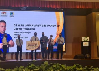 REEZAL Merican Naina Merican menyampaikan anugerah Adiwira Bumi kepada Wan zJohan Ariff Wan Daud pada sambutan Hari Kitar Semula Kebangsaan 2021 di Putrajaya. - UTUSAN/SITI AISYAH SUKAIMI