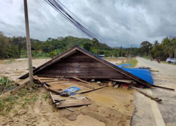 HANYA atap yang tinggal di tepi jalan utama tidak jauh dari rumah mangsa banjir yang lenyap di Kampung Bandar Tinggi. - UTUSAN/NOR AINNA HAMZAH