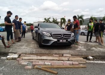 ZAINUDIN Lot (lima dari kanan) bersama beberapa orang awam membantu seorang pemandu membuat pusingan U di Persiaran Tengku Ampuan, Seksyen 22, Shah Alam, Selangor hari ini. - UTUSAN/MOHAMAD NAUFAL MOHAMAD IDRIS