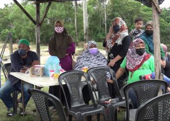 AHLI keluarga Mohd. Halmi Nazlan yang hanyut dibawa arus deras menunggu di lokasi kejadian di Kampung Chempaka, di Kuantan, Pahang.