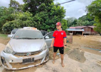 HAZALIZAN Ramli melihat keretanya yang 'total loss' dalam kejadian banjir di Kampung Batu Serambai, Jelebu. - UTUSAN/NOR AINNA HAMZAH