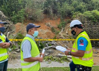 RAHMAD Mariman (kanan) meninjau tembok bukit berhampiran Taman Perumahan Belimbing Setia, Alor Gajah, Melaka yang menempatkan kira-kira 1,500 penduduk runtuh susulan cuaca hujan. - UTUSAN/DIYANATUL ATIQAH ZAKARYA