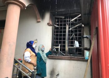 NORHAYATI  Mohd. Nor (kanan) menunjukkan kesan tingkap bilik tidur anaknya yang terbakar di Kampung Menjual Kubang Batang, Tumpat, Kelantan, semalam.– UTUSAN/ROSLIZA MOHAMED