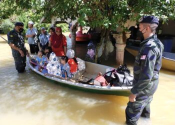 AZHARI Nusi (kiri) bersama anggota membantu memindahkan mangsa yang terperangkap akibat banjir di Kampung  Tersang, Rantau Panjang, Kelantan. - UTUSAN/YATIMIN ABDULLAH