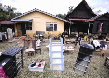 PENDUDUK yang terjejas banjir di Linggi, Port Dickson mengemas dan membersihkan perabot rumah selepas banjir di kawasan tersebut mula surut hari ini. - UTUSAN/MOHD. SHAHJEHAN MAAMIN