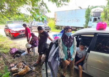 KELUARGA Ernie Watini Aznan memilih tidur dalam kereta selepas rumah mereka dinaiki air di Kampung Sri Tanjung, Dengkil, Selangor. - UTUSAN/SITI A’ISYAH SUKAIMI