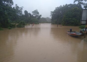 JALAN Jerantut ke Lipis dinaiki air di Simpang Batu Embun berdekatan Kampung Paya Teh di Jerantut, Pahang, ekoran banjir, baru-baru ini. - UTUSAN/HARIS FADILAH AHMAD