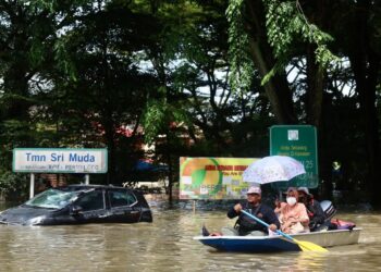 JALAN Bukit Kemuning menghala ke Taman Sri Muda digenangi air dan menjadi lokasi menyelamatkan mangsa banjir yang terkandas di sekitar perumahan itu di Seksyen 25 di Shah Alam, Selangor. - UTUSAN/ZULFADHLI ZAKI