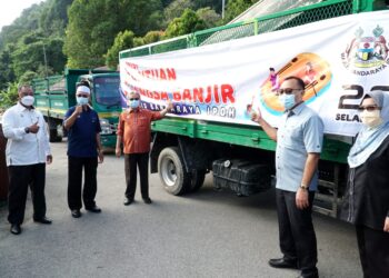 RUMAIZI Baharin (tiga dari kiri) melepaskan pasukan bantuan banjir di Selangor di Taman Rekreasi Gunung Lang, Ipoh hari ini. - UTUSAN/ZULFACHRI ZULKIFLI