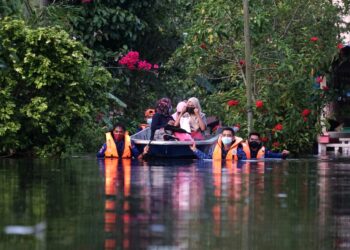 ANGGOTA Angkatan Pertahanan Awam (APM) membantu penduduk yang terjejas banjir di Teluk Intan semalam. - UTUSAN/ZULFACHRI ZULKIFLI