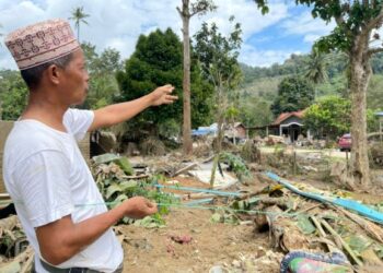 M. Fadzly Pardi menunjukkan pokok tempat dia menyelamatkan diri bersama isterinya selama lapan jam dalam kejadian banjir baru-baru ini ketika ditemui di Kampung Puom, Titi, Jelebu semalam. – UTUSAN/AFIFI HAFIZ MOHD. NOR