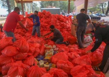 SUKARELAWAN Kelab Diesel 4x4 Terengganu menyusun barangan keperluan yang akan diagihkan kepada mangsa banjir Pahang di Pantai Batu Buruk di Kuala Terengganu. - UTUSAN/PUQTRA HAIRRY ROSLI