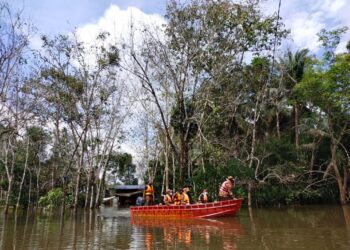 ANGGOTA bomba membuat tinjauan di Kampung Padang Licin, Rantau Panjang, Kelantan yang kini digenangi air banjir termenung sejak minggu lalu. - UTUSAN/ YATIMIN ABDULLAH