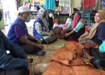 IDRIS Ahmad (duduk, dua dari kiri) melawat dan melihat keadaan mangsa banjir sekali gus menyalurkan bantuan berupa barangan keperluan asas kepada kira-kira 350 buah keluarga yang ditempatkan di PPS SK Desa Bakti di Mentakab, Temerloh, Pahang. - UTUSAN/ DIANA SURYA ABD WAHAB