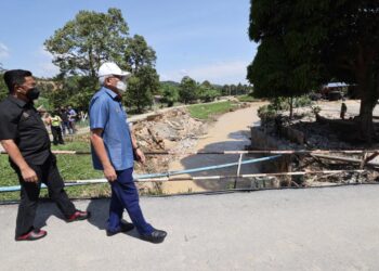 MAHDZIR Khalid (kanan) diiringi Jalaluddin ketika meninjau keadaan sebuah jambatan yang runtuh di Kampung Kemin, Jelebu hari ini selepas kejadian banjir baru-baru ini.