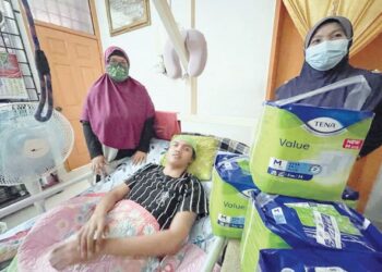 MUHAMMAD Faiz Hafizuddin bersama ibunya menerima kunjungan aktivis masyarakat, Siti Rohana Jusoh (kanan) yang turut menyumbangkan bekalan lampin pakai buang di rumah keluarga itu di Selising, Pasir Puteh, semalam. - UTUSAN/TOREK SULONG