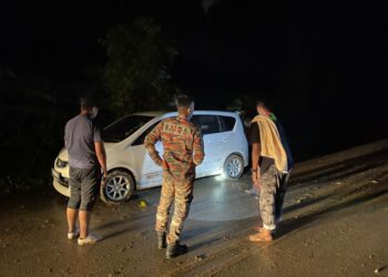 ANGGOTA Bomba membantu dan menyelamatkan mangsa yang terkandas Jalan Kuala Klawang-Genting Peras di sini malam semalam. - GAMBAR/IHSAN BOMBA