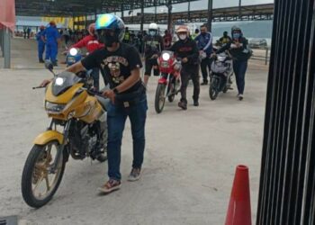 SEBAHAGIAN penunggang menolak motosikal untuk diperiksa oleh polis sejurus tiba di Kompleks Dermaga Tanjung Lembong, Langkawi semalam.