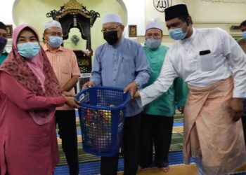 AHMAD Yakob menyampaikan sumbangan kepada mangsa banjir di di Masjid At-Taqwa Kampung Lakota, Jeli, Kelantan hari ini. - UTUSAN/YATIMIN ABDULLAH