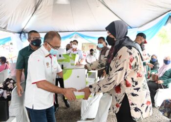 ABDULLAH Zainal (kiri) menyampaikan sumbangan bakul makanan kepada mangsa banjir di Bera, Pahang. - FOTO/SALEHUDIN MAT RASAD