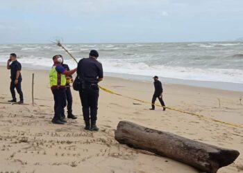 ANGGOTA polis memeriksa lokasi penemuan mayat reput di Pantai Mengabang Panjang di Batu Rakit di Kuala Nerus, hari ini.