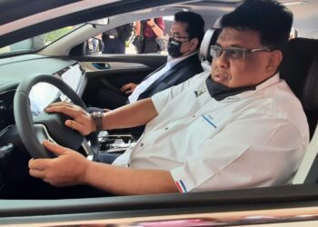 AB. Rauf Yusoh (kiri) dan Sulaiman Md. Ali mencuba memandu kereta elektrik hasil teknologi Changan Automobile Corporation di Seri Negeri, Ayer Keroh, Melaka. - UTUSAN/AMRAN MULUP