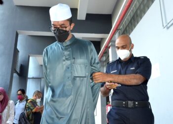 AZIZUL Yahya (kiri) dibawa keluar dari Mahkamah Sesyen Ipoh hari ini atas 15 tuduhan amang seksual terhadap lima pelajar lelaki tahun lalu. - UTUSAN/ZULFACHRI ZULKIFLI