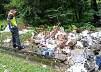 SEORANG anggota penguat kuasa SWCorp meninjau salah satu tempat pembuangan sampah haram di Negeri Sembilan.