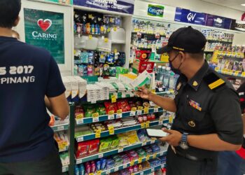 PENGUAT KUASA KPDNHEP Melaka melakukan pemeriksaan harga dan bekalan RTK antigen Covid-19 di sebuah farmasi di Melaka. - UTUSAN/MUHAMMAD SHAHIZAM TAZALI