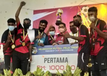 AHMAD Faizal Azumu (tengah) bersama pemain pasukan yang menjuarai Kejohanan Futsal Peja Trophy Peringkat DUN Chenderiang di Tapah hari ini. - UTUSAN/SAYED HESHAM IDRIS