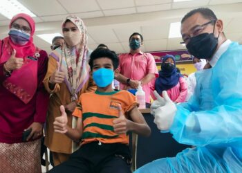 MURID Tahun Lima, Nur Adib Darwisy Nordin menerima suntikan vaksin daripada Dr. Noor Azmi Ghazali ketika beliau meninjau proses pemberian vaksin PICKids di SK Saujana Indah, Nibong Tebal, Pulau Pinang hari ini.