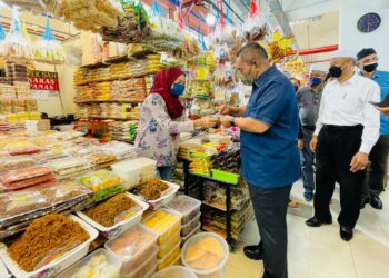 MUHAMMAD Sanusi Md Nor meninjau salah sebuah gerai menjual makanan ringan ketika melakukan Walkabout di Pekan Rabu, Alor Setar hari ini. - UTUSAN/JAMLIAH ABDULLAH