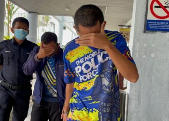 MOHD. SYAIFULLAH Ismail (kanan) dan Muhammad Amirullah Abdul Razak (tengah) diiringi anggota polis selepas didakwa di Mahkamah Majistret  Ayer Keroh, Melaka. - UTUSAN/DIYANATUL ATIQAH ZAKARYA